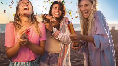 Drei Frauen die sich riesig über eine Konfettikanone freuen