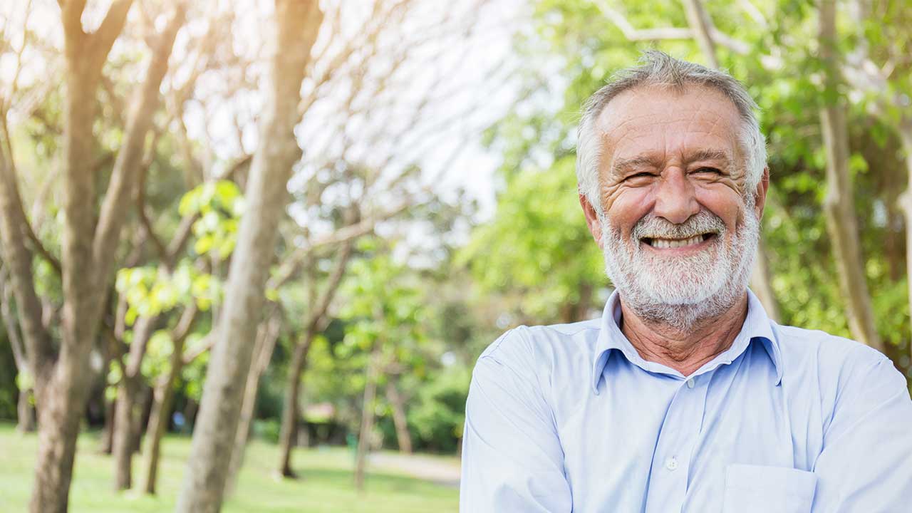 finvesto Kombiplan Lächelnder älterer Mann mit Bart in der Natur