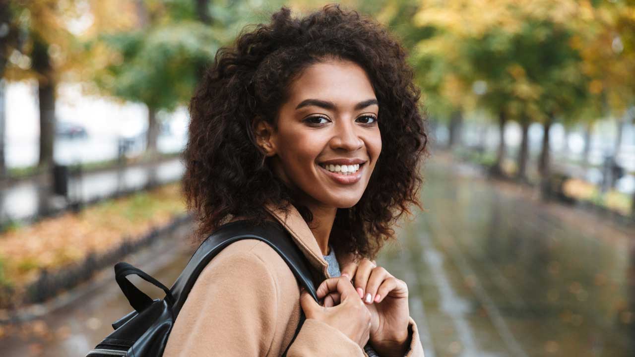 Festgeld Lächelnde Frau mit Rucksack