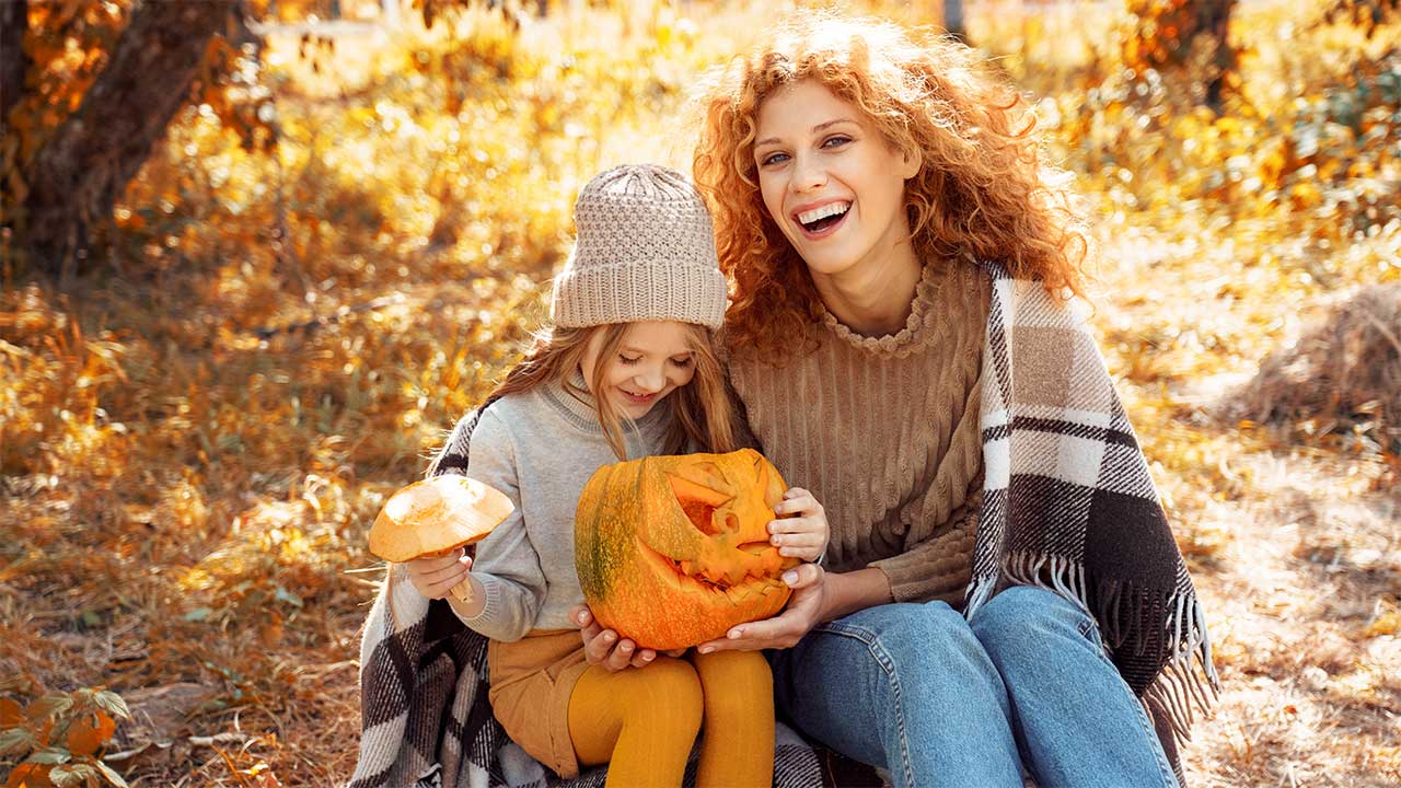 Wertpapiere einfach erklärt Mutter und Tochter halten einen geschnitzten Kürbis